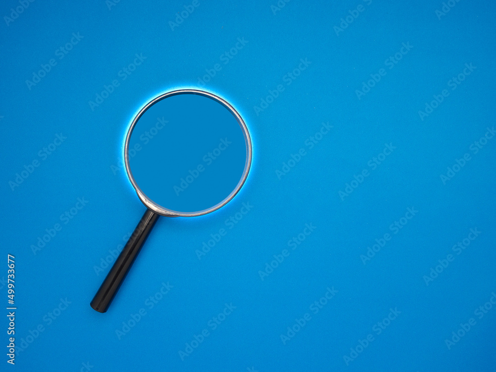 Search concept. A magnifying glass on a blue background with copy space for text Search concept. A magnifying glass on a blue background with copy space for text