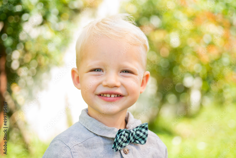 Spring kids smiling portrait. Closeup face of cute smiling spring child. Kid emotions concept. Portrait of young laughing boy outdoor. Blonde child. Happy kids emotions, smiling face.