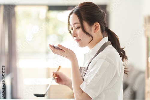 Obraz na płótnie キッチンで料理をするアジア人女性