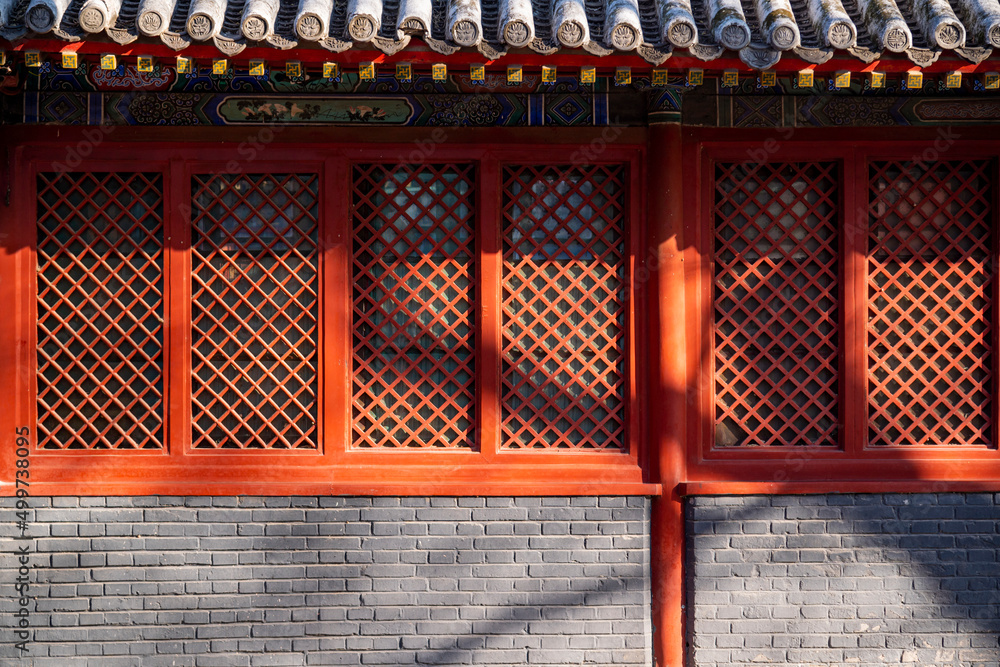 Red wooden window with decoration colorful painting beam and wood pole from ancient china palace in forbidden City, Beijing, China