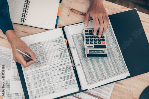 Investors working on desk office and using a calculator to calculate balance, projit, currency and cost. Accounting and Financial concept.