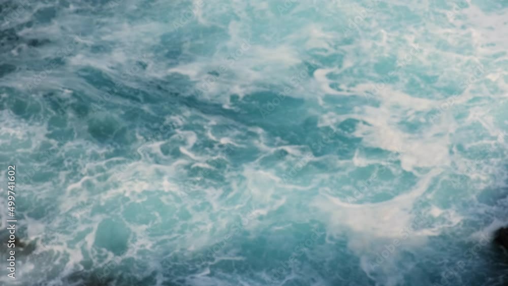 View of the blue sea water down, waves with a lot of foam breaking up. View of the blue sea water down, waves with a lot of foam breaking up.