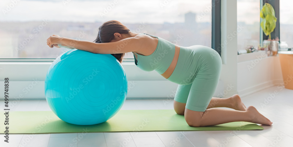 Pregnant woman training labor position stretch kneeling on birthing ball on her hands and knees stretching home pregnancy workout banner - obrazy, fototapety, plakaty 
