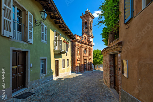 Narrow cobblestone street and small church in Guarene  Italy.