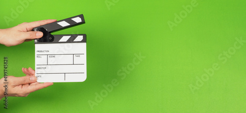 Foto The hands are holding a small clapper board or movie slate on the green screen background
