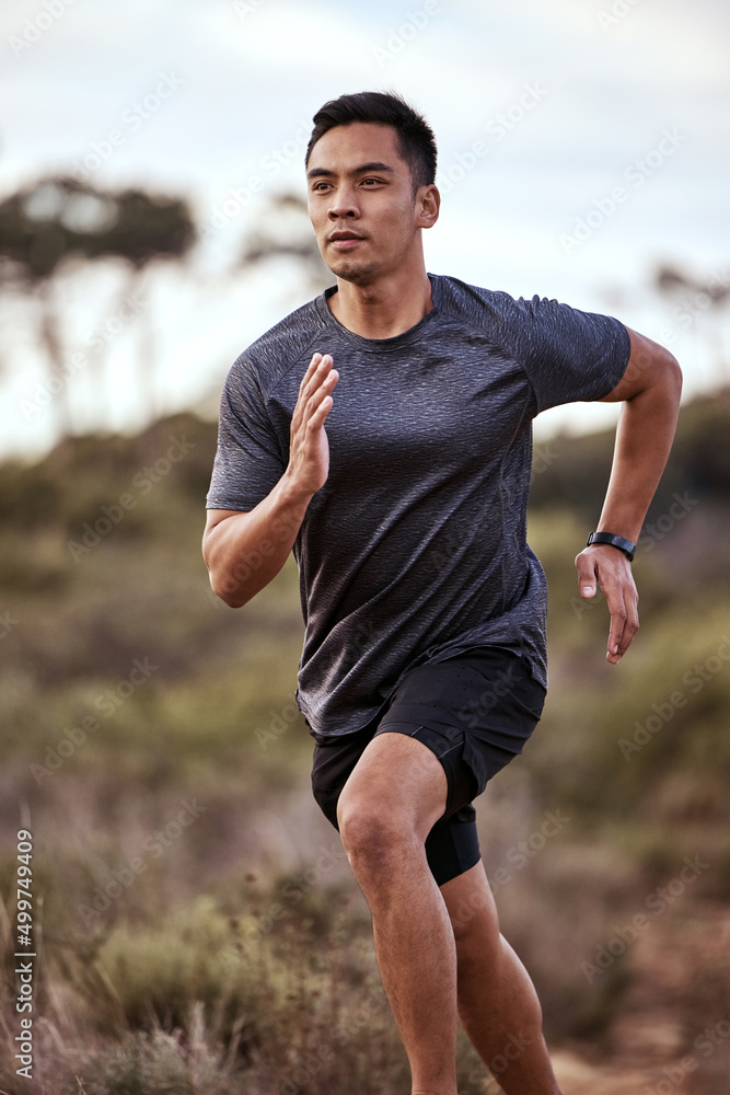 Fototapeta premium Running clears the mind of all worries. Shot of a young man exercising in nature.
