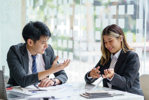 Wallpaper Mural Two Asian business people discuss with new startup project Idea presentation, analyze planning at office. Torontodigital.ca