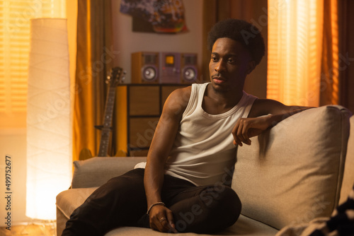 Картината върху платно Man with dark skin and afro of African-American descent sits worried, sad on cou