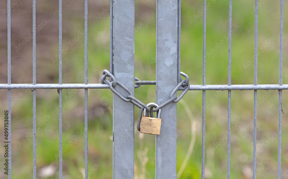 Large metal fence locked with a padlock and a chain Large metal fence locked with a padlock and a chain