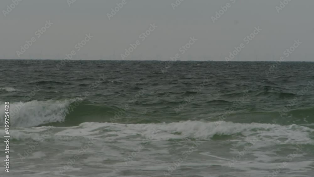 Sad and moody looking ocean waves crashing on shoreline, static view Sad and moody looking ocean waves crashing on shoreline, static view