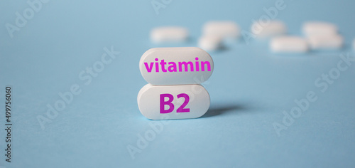 The inscription vitamin B2 on white tablets is a close-up on a blue background. Riboflavin.