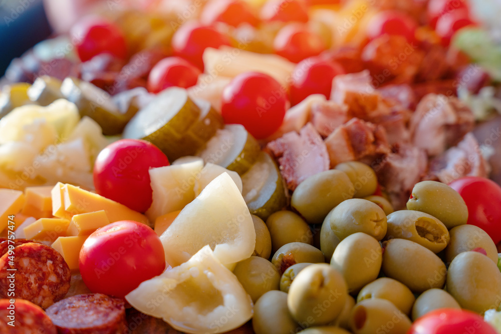 cherry tomatoes, sweet peppers, pickled cucumbers, pickled garlic, olives, sausage, different cheese, bacon on wooden plate. Snack food cherry tomatoes, sweet peppers, pickled cucumbers, pickled garlic, olives, sausage, different cheese, bacon on wooden plate. Snack food