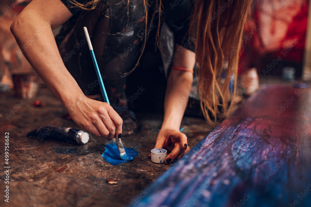 Obraz premium Woman artist hand holding colorful paintbrushes while painting