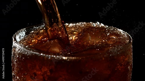 Brown Sweet Sparkling Water is Poured into a Glass with Ice Cubes