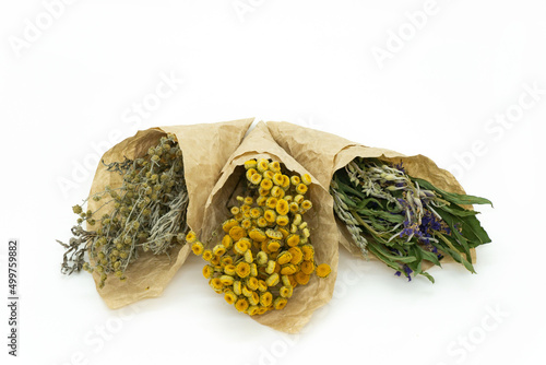 Dried herbs and flowers isolated on white background. Bundles of medicinal herbs for tea. Yellow, purple and green dried flowers. Alternative medicine.