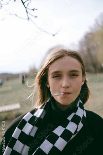portrait of a girl sitting in the park and happily smoking marijuana