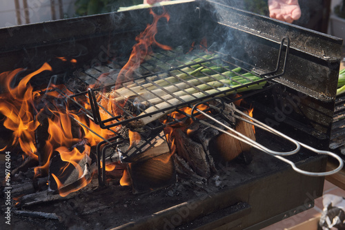 A pile of calçots, a Catalan grilled tender onions. Detail of the flames.