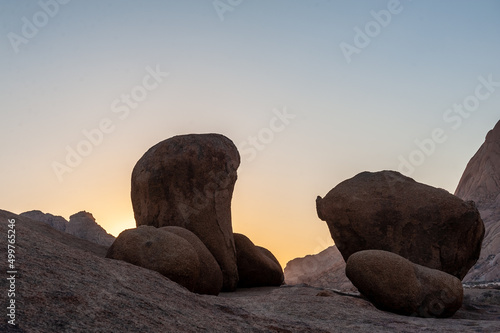 Giant boulders contrast with a yellow glow of the setting sun. Spitzkoppe area, Namibia.