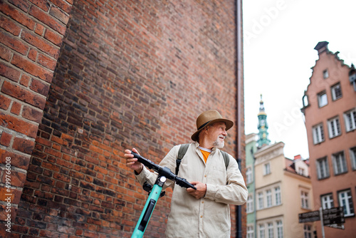 Wallpaper Mural Portrait of happy senior man tourist riding scooter outdoors in town Torontodigital.ca
