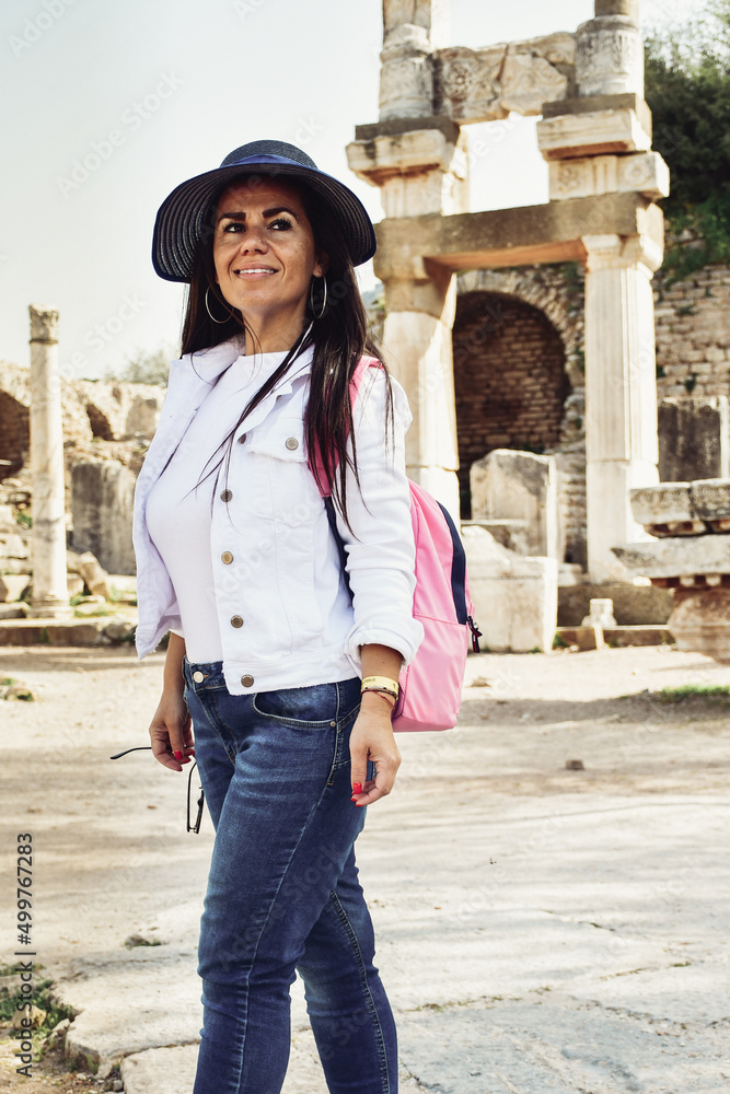  Beautiful smiling Tourist Woman  traveling  in the    ruins of Celsus in Ephesus Ancient City at Efes  Selcuk Izmir Turkey 