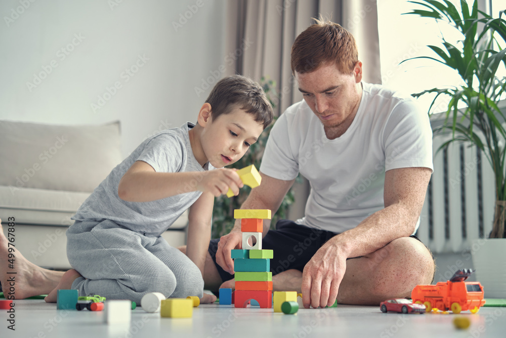 smiling father and little son playing with colorful blocks together at home. Playtime. diverse family smiling father and little son playing with colorful blocks together at home. Playtime. diverse family