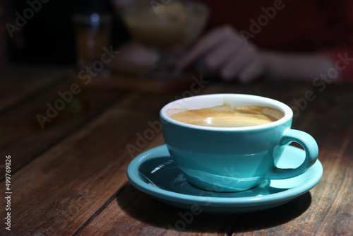Hot black coffee or Americano in blue ceramic cup on wooden table background. 