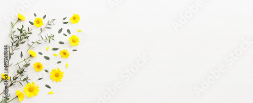 Foto Top view image of yellow chrysanthemum field flowers composition over wooden white background