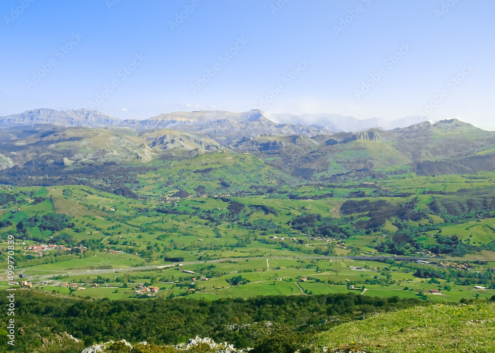 Views of the green Pas region valleys (Valles Pasiegos) and its peaks: Fraile peak (Pico Fraile) and Castro Valnera peak (Pico Castro Valnera). At Peña Cabarga Llen peak in Santander, Cantabria.