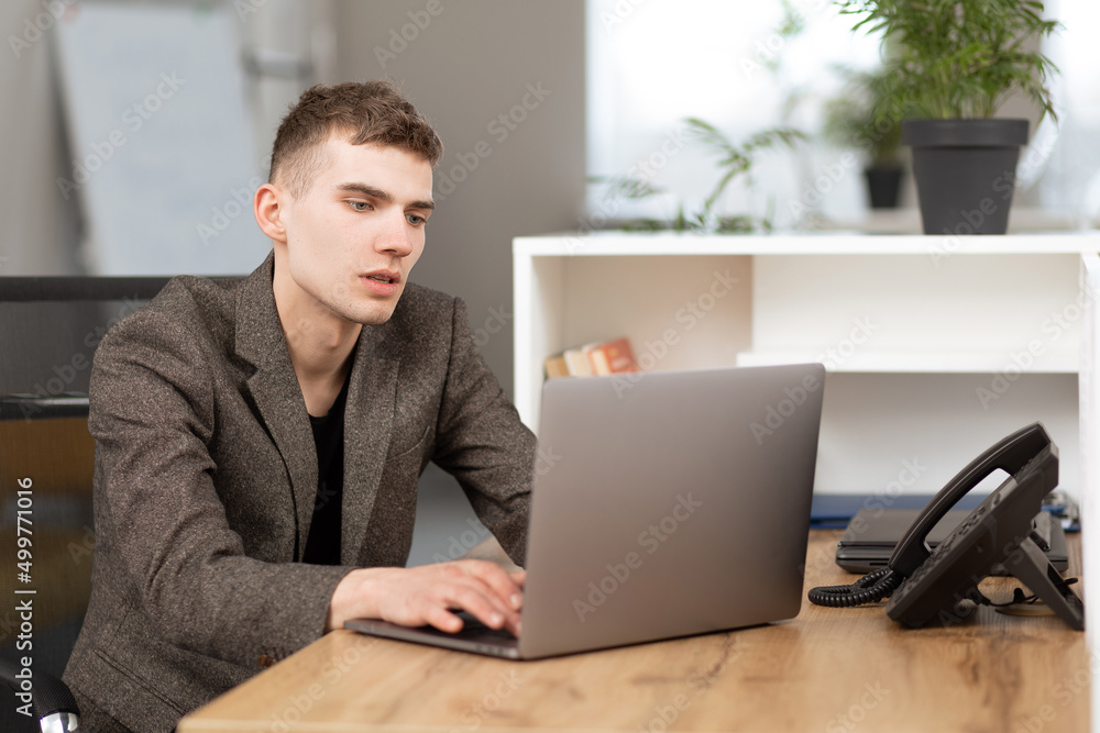 young handsome manager working in the office on a laptop young handsome manager working in the office on a laptop