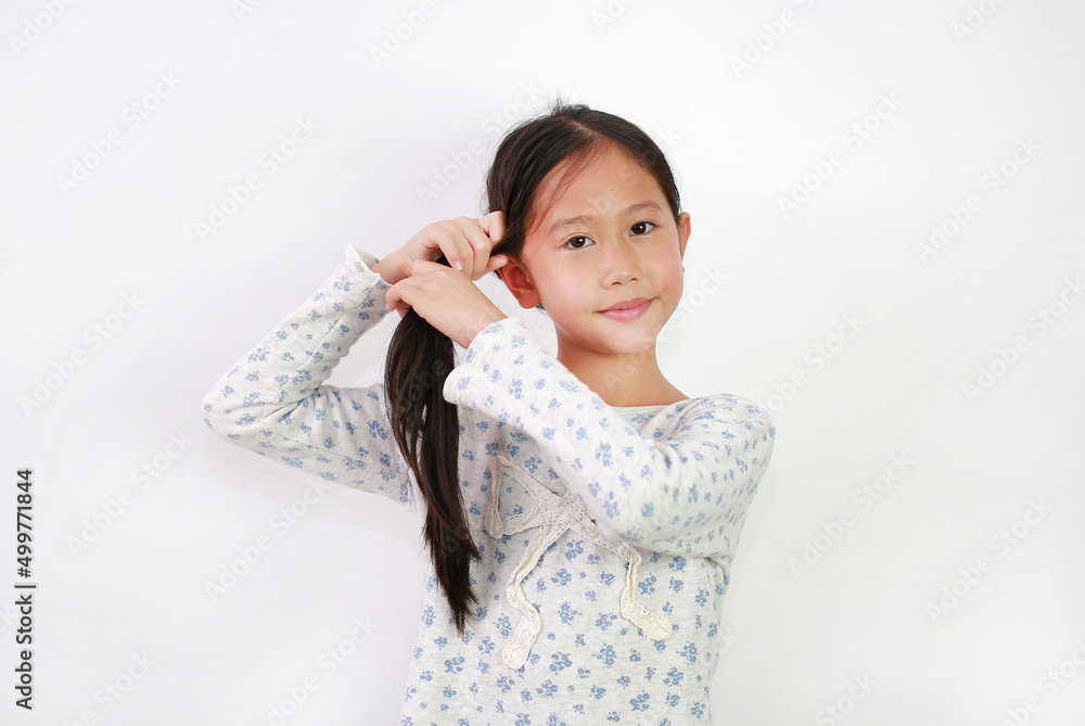 Portrait of Asian young girl kid tie her hair and looking at camera on white background. Child Care concept. Portrait of Asian young girl kid tie her hair and looking at camera on white background. Child Care concept.