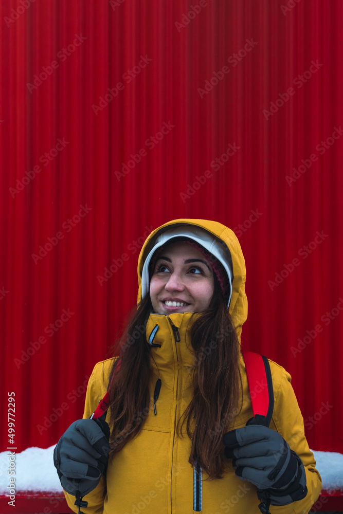 smiling brunette woman in yellow coat.