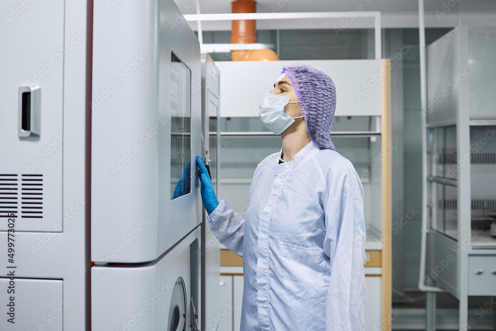A female scientist checks the readings on the equipment in the laboratory