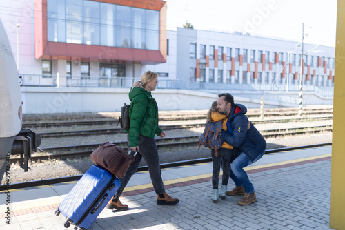 Ukrainian refugee family hugging at railway station together  reunion after war.