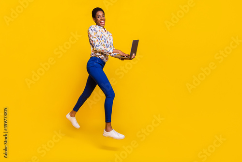 Full size profile portrait of active programmer person use wireless netbook isolated on yellow color background