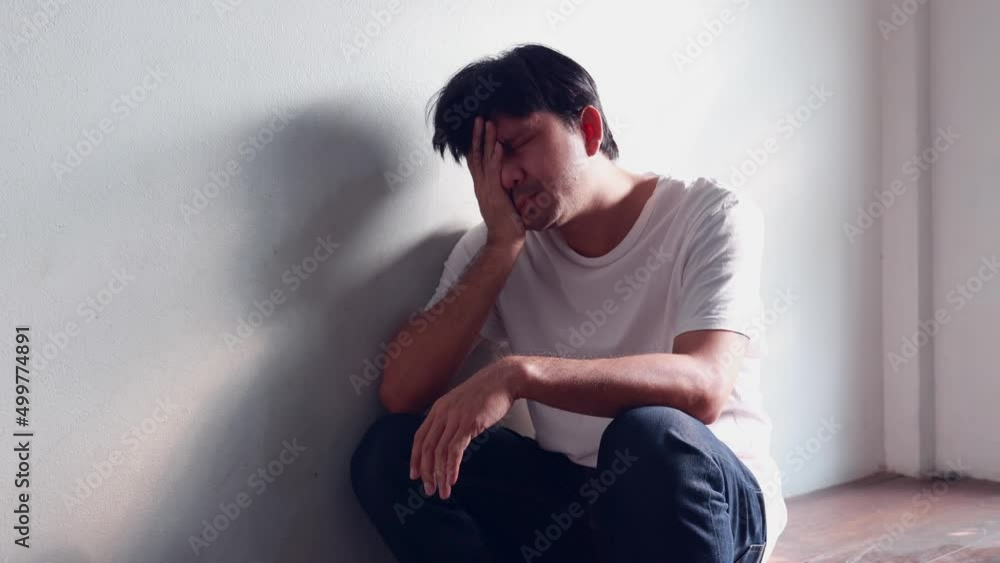 Asian man leans against a wall with stress, depression, and despair, man has life problems Asian man leans against a wall with stress, depression, and despair, man has life problems