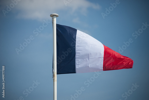 Obraz na plátně Closeup of french flag floating on blue sky background
