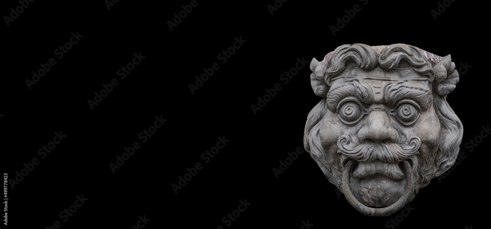Obraz premium Banner with a sculpture of mysterious scary ancient creature in downtown of Potsdam, Germany, with copy space black background. Concept of historical architecture heritage.