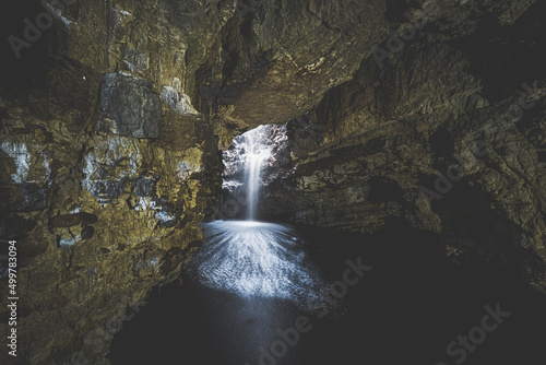 Waterfall flowing into cave