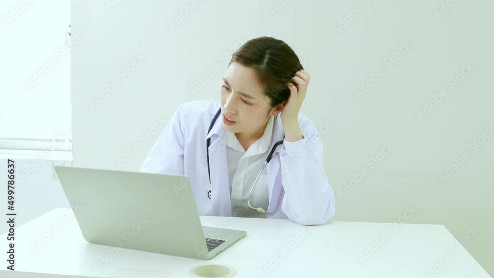 Overworked asian female doctor sitting on his desk he was irritated, exhausted and stressed about hospital problems. Overworked asian female doctor sitting on his desk he was irritated, exhausted and stressed about hospital problems.