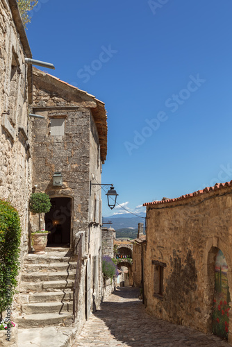 Typical for vernacular architecture buildings, constructions, streets of restored old village Lacoste under blue sky, Vaucluse, France