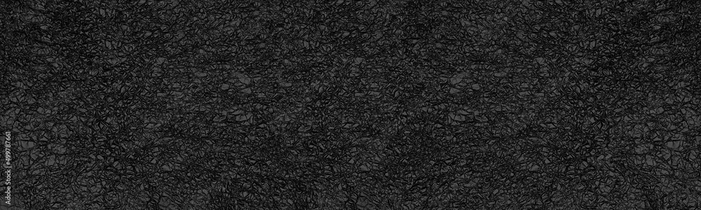 Fototapeta premium Crumpled black foil surface top view wide panoramic texture. Dark gray abstract large long background