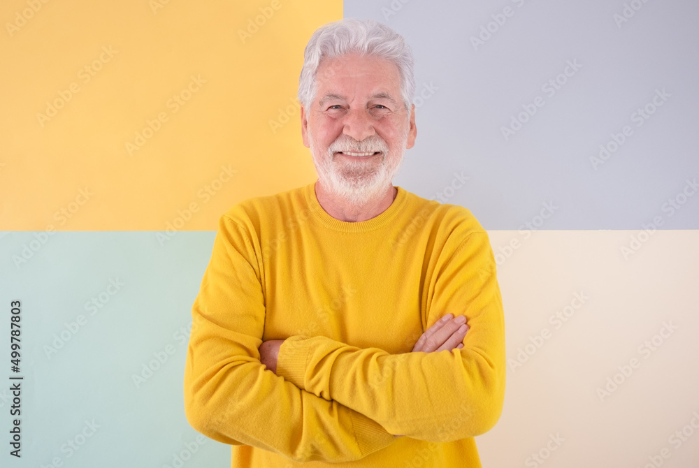 Smiling senior bearded caucasian man with crossed arms looking at camera . Handsome senior grandfather standing on a colorful isolated background expressing relax and positivity Smiling senior bearded caucasian man with crossed arms looking at camera . Handsome senior grandfather standing on a colorful isolated background expressing relax and positivity