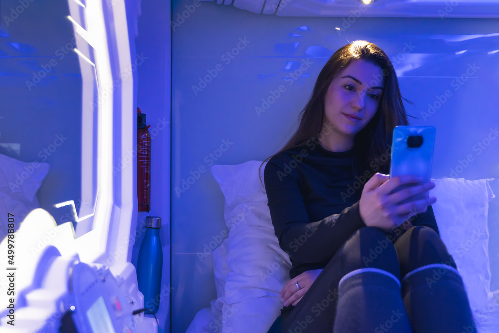 woman in capsule at night with the phone