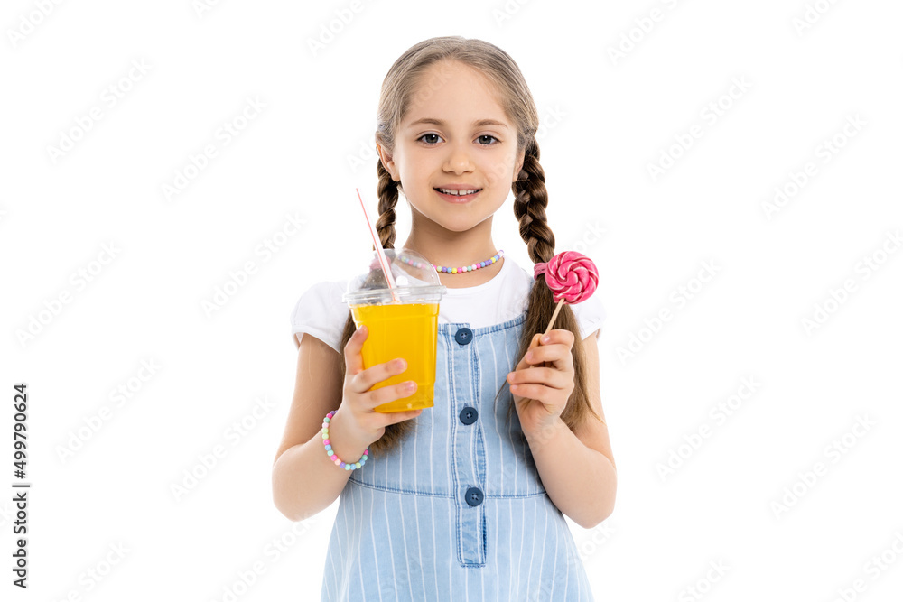 cheerful girl with orange juice and lollipop looking at camera isolated on white. cheerful girl with orange juice and lollipop looking at camera isolated on white.