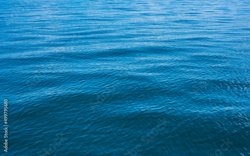 Blue water background with ripples Sea low angle view, Ocean, Wave. Travel destination and nature environment concept.