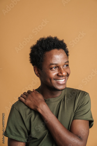 Young black man wearing t-shirt smiling and looking aside