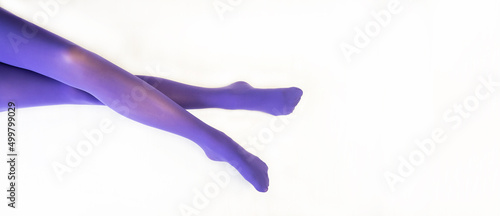 Legs of a beautiful young girl in lilac tights. White background.
