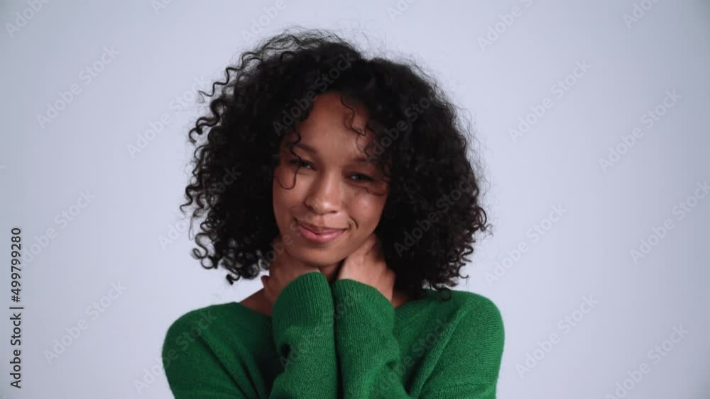 Laughing curly-haired woman posing at the camera in the grey studio Laughing curly-haired woman posing at the camera in the grey studio
