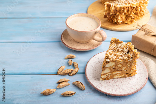Traditional lithuanian cake shakotis with cup of coffee on blue, side view, copy space.