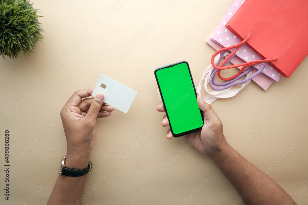 Obraz premium Man hand holding credit card and using smart phone shopping online 